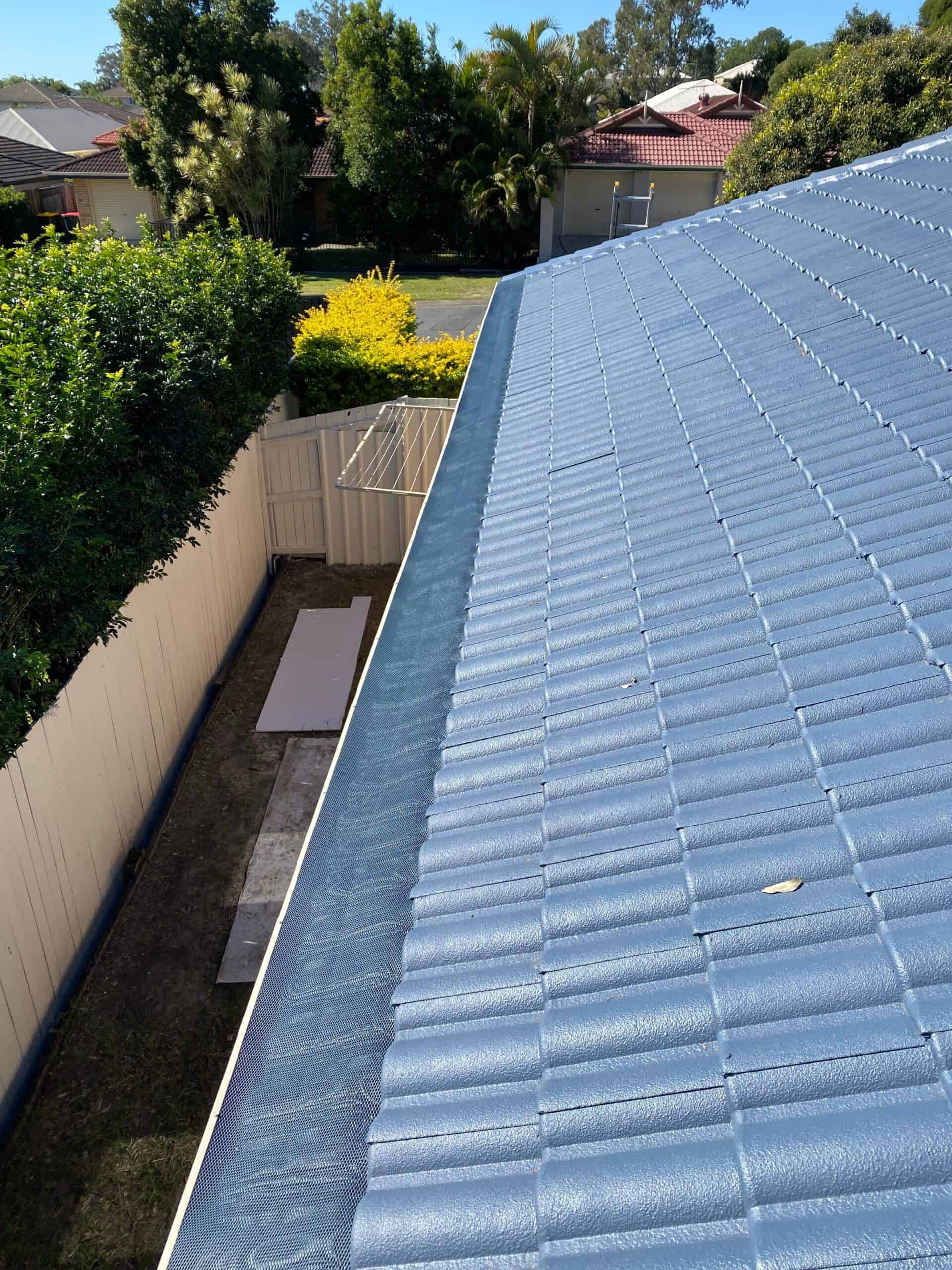 Gutter guard installation on a blue roof